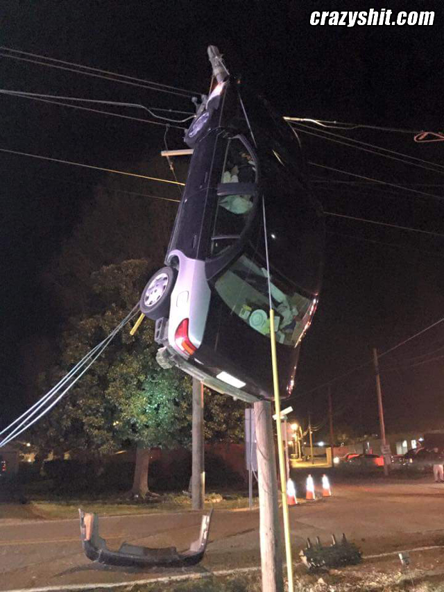 Car Hangs From Telephone Pole