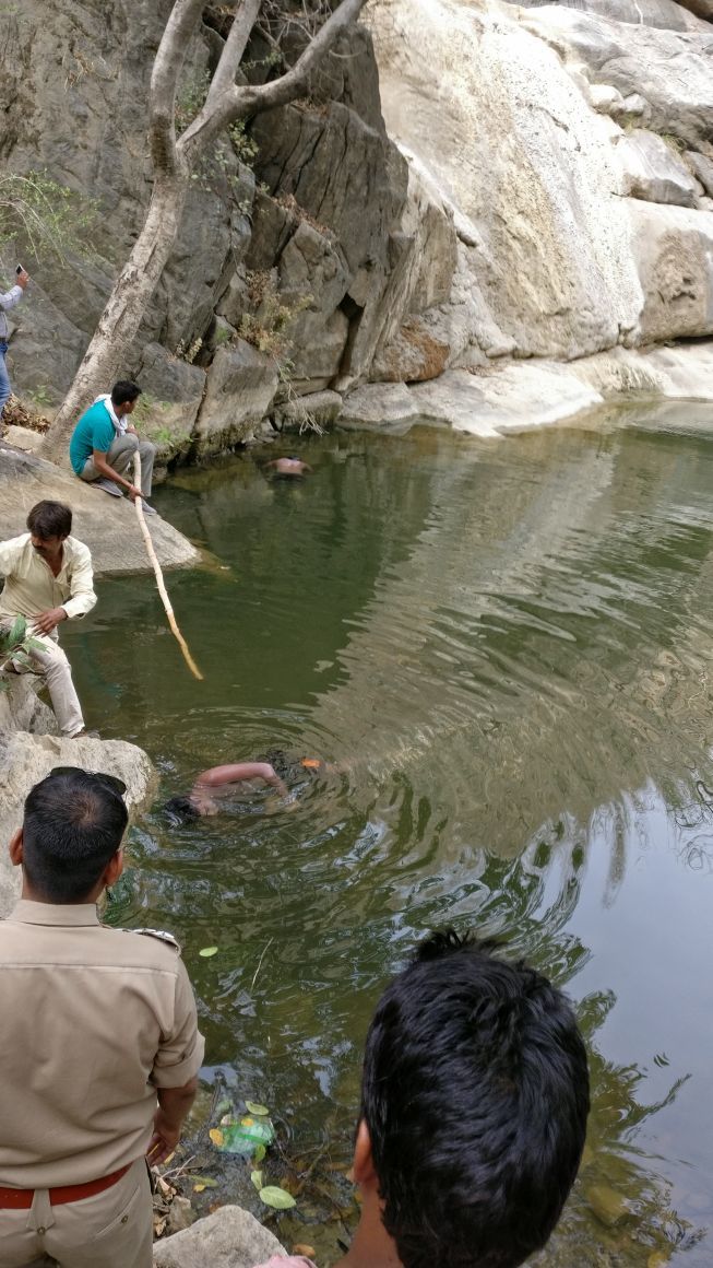 Guys (looks like from India) Clowning around a watersource.
