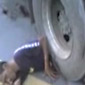 Truck moves tire with man pinned underneath