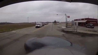 A car turns in front of a tractor trailer