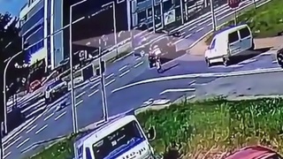 A dude on a motorcycle hits a car and flips