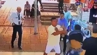 A crowd demonstrates the proper way to handle a laptop thief