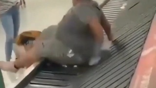 Phat man pushed onto airport luggage turntable...he can't got off it!